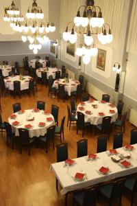 a dining room with white tables and chairs and chandeliers at Hotel Lavica in Samobor