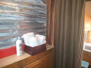 a basket of toilet paper sitting on a shelf in a bathroom at La loma del chivo Llc Stone Cottage alternative building in Marathon