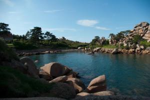 Une rivière avec des rochers et des gens qui y nagent dans l'établissement Arty, à Louannec