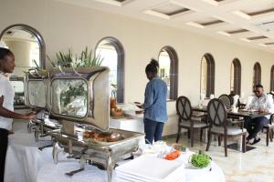 a group of people standing in a room with food at Hotel Amaritsah in Brazzaville