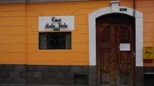 an orange building with a door and a sign on it at Casa Bella Vista Quito Centro Histórico in Quito