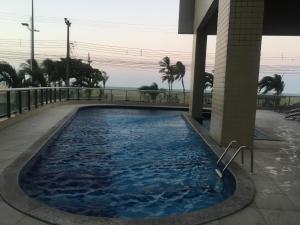 una gran piscina con el océano en el fondo en Terraço do Atlântico, en Fortaleza