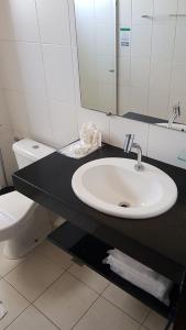 a bathroom with a sink and a toilet at Lavras Apart Hotel in Lavras +10 photos