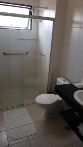 a bathroom with a shower and a toilet and a sink at Lavras Apart Hotel in Lavras