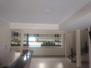 a living room with a large window in a building at Hotel farol de Minas in Alpinópolis