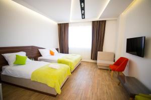 a hotel room with two beds and a television at Garni Hotel Apel Apartments in Niš