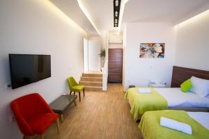 a hotel room with two beds and a television at Garni Hotel Apel Apartments in Niš