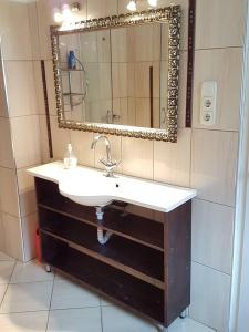 a bathroom with a sink and a mirror at Szőke Tisza Vendégház in Szajol