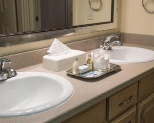 
a white sink sitting under a mirror in a bathroom at Lodge at Kingsbury Crossing in Stateline
