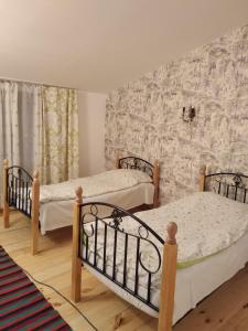 a bedroom with two beds in a room with a wall at Artson B&B Vagharshapat in Vagharshapat