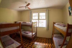 a room with three bunk beds and a window at Floripa Camping e Hostel Florianopolis SC in Florianópolis