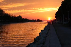 a sunset over a body of water with the sun setting at Studio 237 Port Camargue, Piscine, Climatisation, 2 personnes in Le Grau-du-Roi