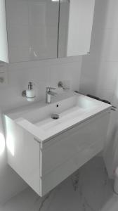 a white bathroom with a sink and a mirror at Hydro Palace in Ostend