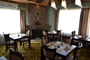 a dining room with tables and chairs and a fireplace at City Stay in Maseru