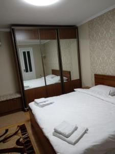 Un dormitorio con una cama y un espejo grande. en Гостьовий будинок Кам'янець - Подільський, en Kamianets-Podilskyi