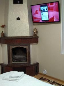 TV colgada en una pared con chimenea en Гостьовий будинок Кам'янець - Подільський, en Kamianets-Podilskyi