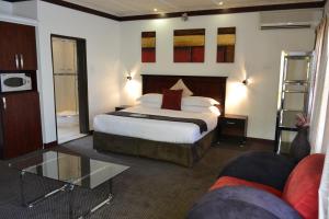 Habitación de hotel con cama y sofá en City Stay, en Maseru
