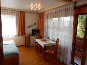 ein Schlafzimmer mit einem Tisch, einem Bett und einem Fenster in der Unterkunft Ferienwohnung Reichmann in Bodensdorf