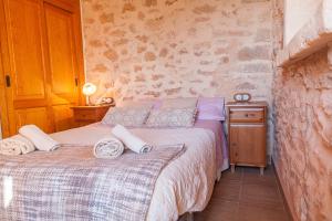 a bedroom with a bed with towels on it at Es moli de na Sebastiana in Ses Salines