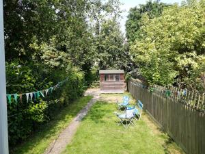 a backyard with a shed and a table and chairs at Lovely Terraced 2-Bed House (near Hinksey Park) in Oxford