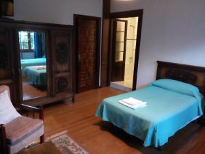 a bedroom with a bed and a mirror at Hotel Rural La Lastra in Caso