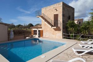a villa with a swimming pool in front of a house at Es moli de na Sebastiana in Ses Salines