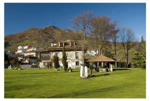 een groot huis in een veld van groen gras bij Hotel Rural La Lastra in Caso