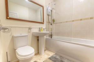 a bathroom with a toilet and a sink and a bath tub at Stirling Central Apartment in Stirling