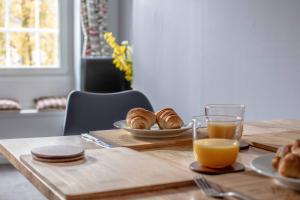 a table with a glass of orange juice and croissants at Stirling Central Apartment in Stirling