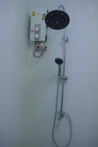 y baño con ducha y cabezal de ducha. en Sri Samui, en Nathon