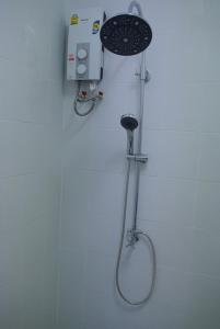 a shower in a bathroom with a shower head at Sri Samui in Nathon