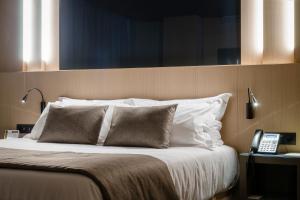 
a bed with a white comforter on top of it at Hotel Metropolis in Andorra la Vella
