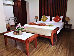 a bedroom with a large bed and a table at Phi Phi Ba Kao Bay Resort in Phi Phi Don