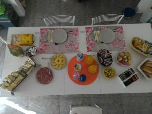 una mesa cubierta con diferentes tipos de galletas y comida en B&B Il Corallo, en Bosa