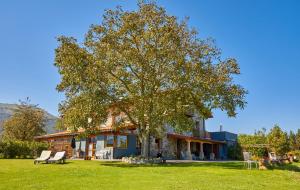 ein Haus mit einem großen Baum im Hof in der Unterkunft URAIN Suites - Apartments at Flysch-Coast in Zumaia