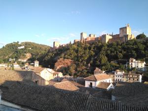 a castle on top of a hill with houses at Casa-Mirador La Alhacena in Granada