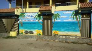 un murale della spiaggia sul lato di un edificio di Pousada Lirio dos Vales a Prado