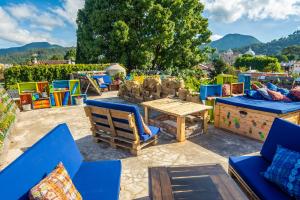 un patio con sillas y una mesa y sillas de madera. en The Purpose Hostel en Antigua Guatemala