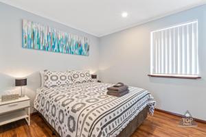 a bedroom with a bed with a black and white comforter at Mandurah Caravan and Tourist Park in Mandurah