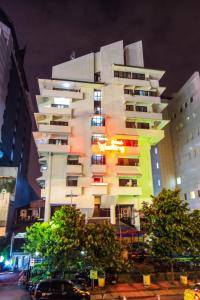 a tall white building with colorful windows at night at Grand Menteng Hotel in Jakarta