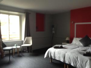 Saint-AuventにあるAuberge de la vallee de la gorreの赤い壁のベッドルーム1室(ベッド1台付)