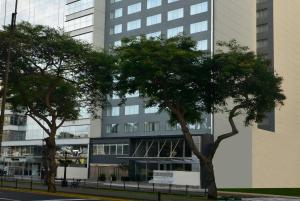 dos árboles frente a un edificio alto en Dazzler by Wyndham Lima Miraflores en Lima