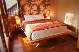 a bedroom with a bed with two lamps on it at Petit Tree in Seminyak