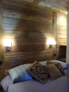 a bedroom with wooden walls and a bed with pillows at La Petite Suite in Megève