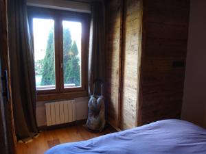 a bedroom with a bed and a large window at La Petite Suite in Megève