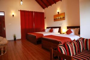two beds in a hotel room with red curtains at Avonil Resort Yala in Tissamaharama