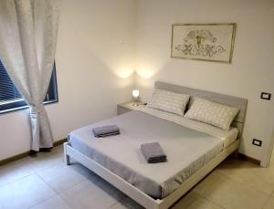 una camera da letto con un letto e due asciugamani di Appartamenti la Piazzetta vicino a Firenze a Signa