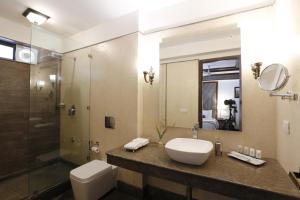 a bathroom with a toilet a sink and a mirror at The Naini Retreat, Nainital by Leisure Hotels in Nainital
