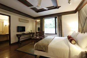 a hotel room with a large bed and a large window at The Naini Retreat, Nainital by Leisure Hotels in Nainital