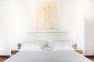ローマにあるAndreasuite Trastevereの白いベッド(白い枕付)が備わるベッドルームです。